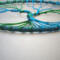 bottom of tree show roots anchored to teal color yarn wrapped metal hoop